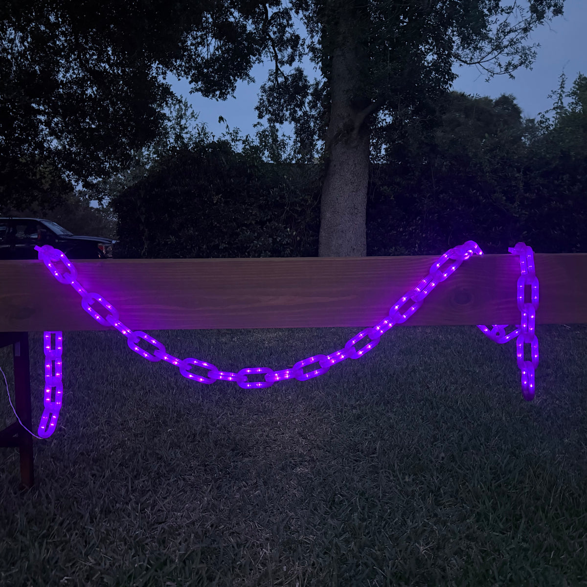 Purple String of Chains Lights illuminated at night, swaged on a centerboard