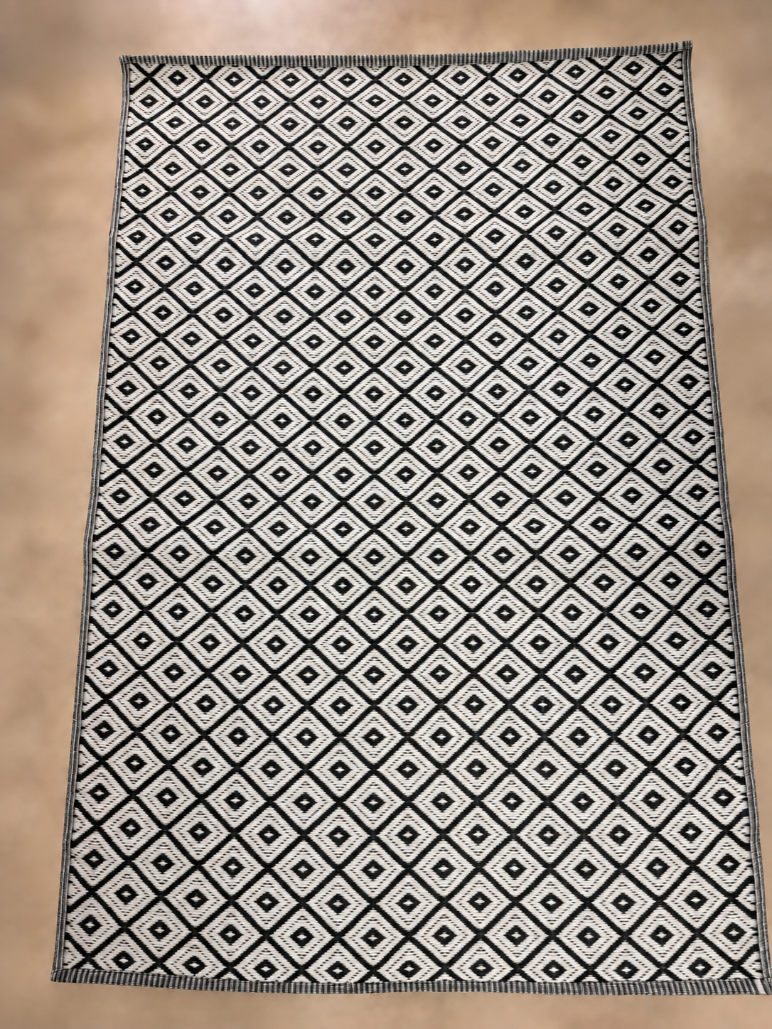 Cream-white reverse side of same rug with black diamond pattern