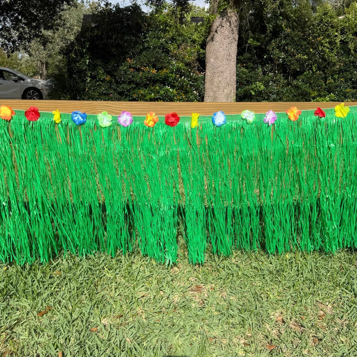Decorative setup with colorful flowers and green grass-like material on a grassy background