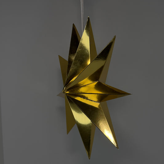 A metallic gold hanging star ornament with a reflective, crinkled texture, suspended against a plain gray background.