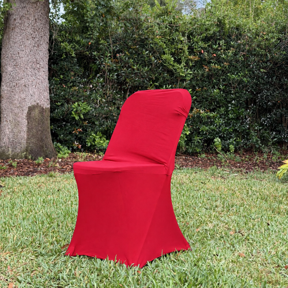 Red standard spandex folding chair cover in the Cove Kits yard setting