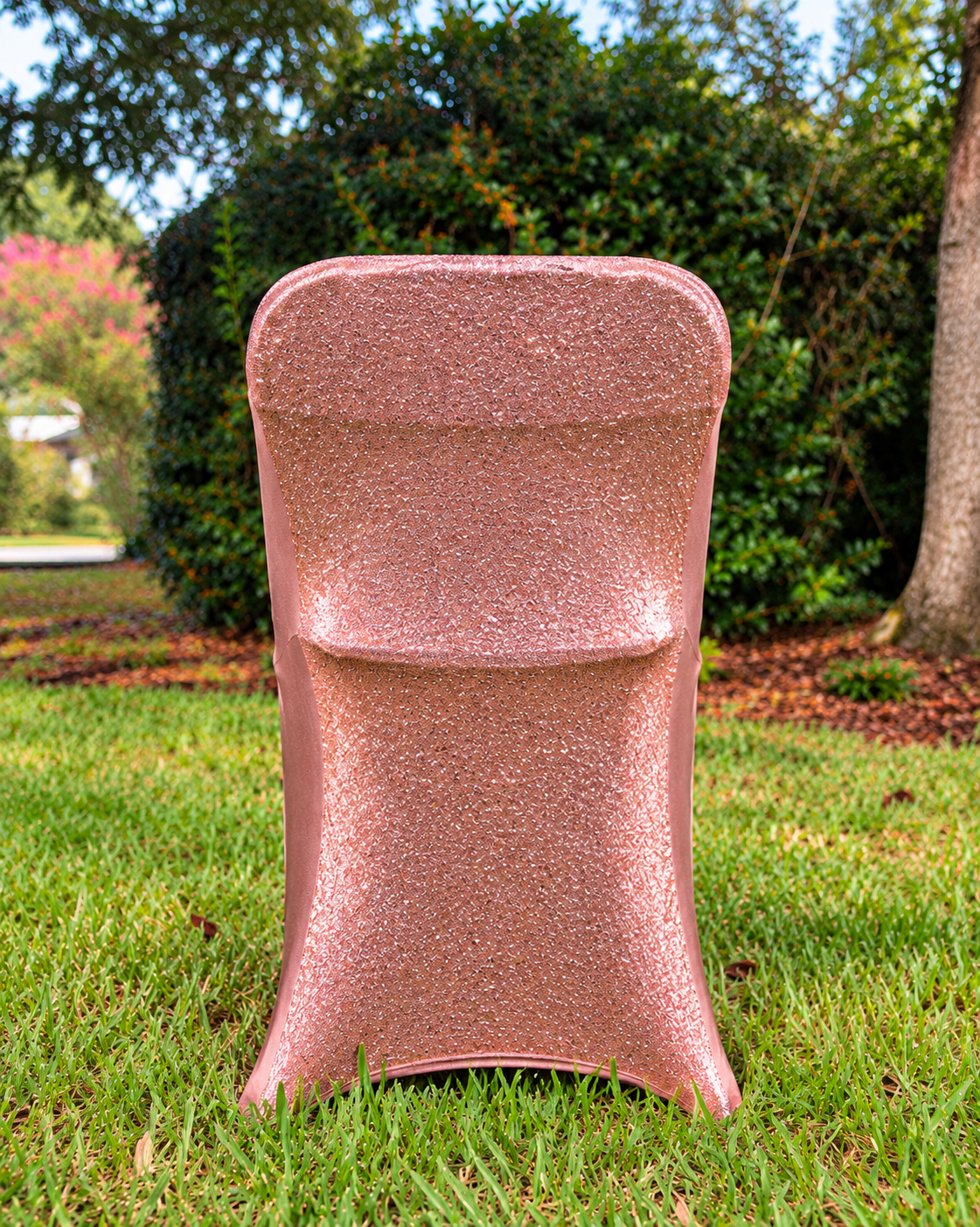 Rose gold metallic shimmer chair cover in garden setting; styled product visualization