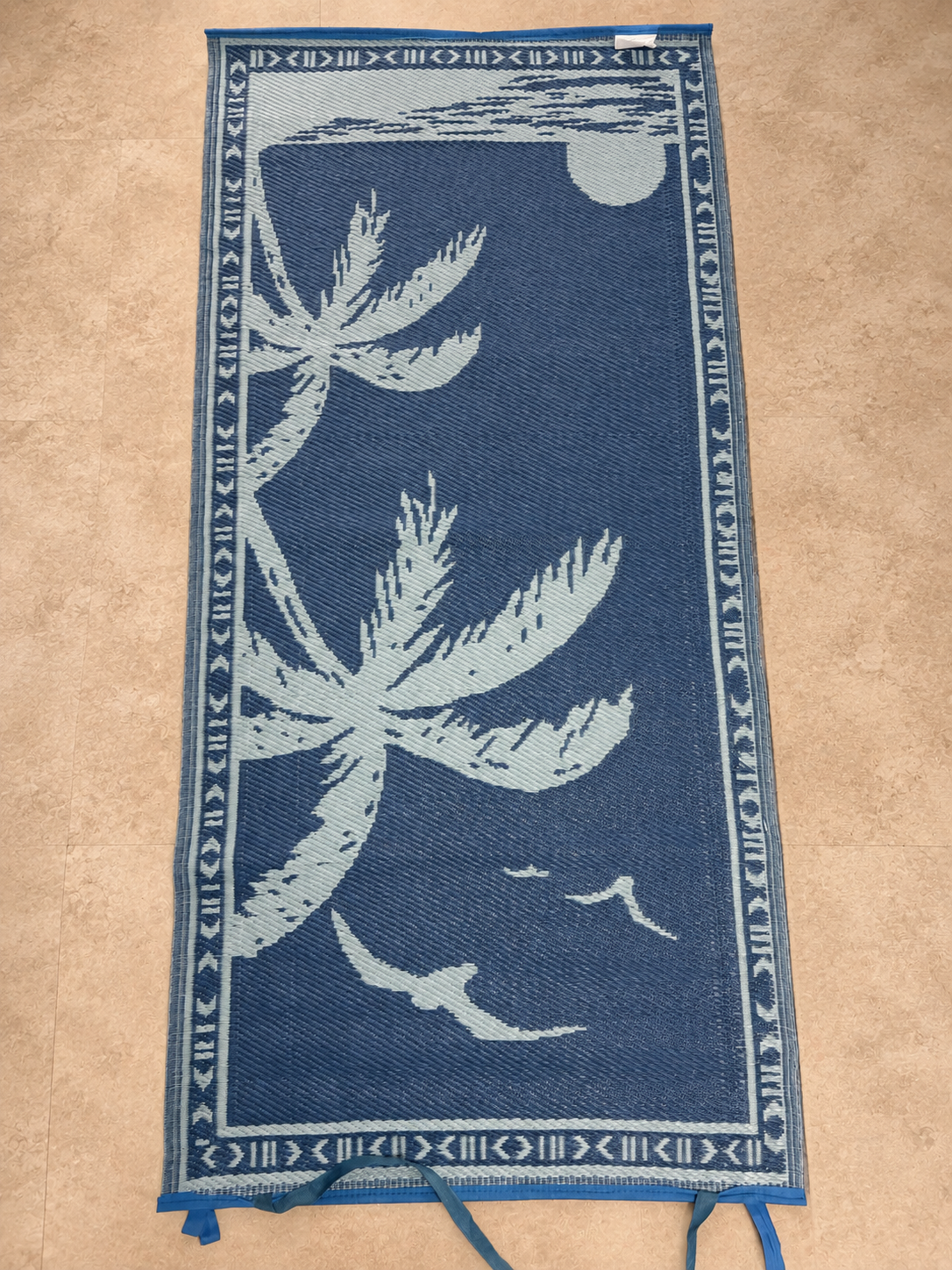 Dark blue reverse side of the same rug with light blue palm trees and birds
